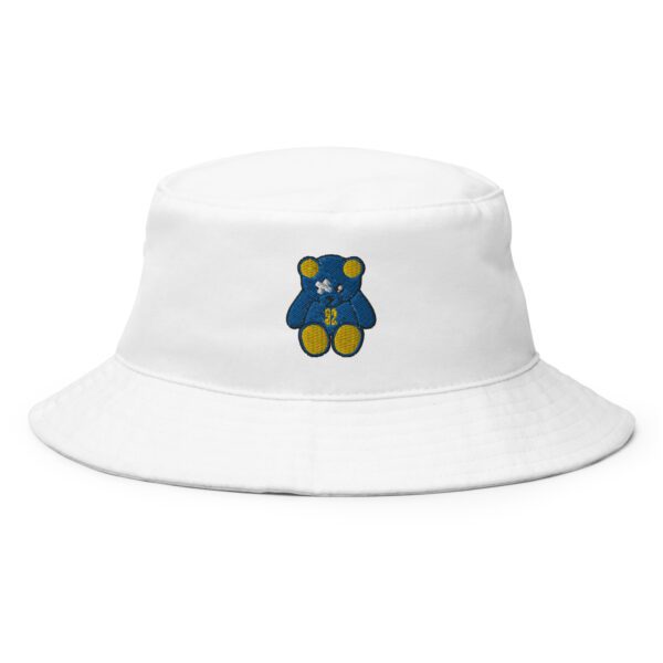 A white bucket hat with a blue and yellow teddy bear on it.