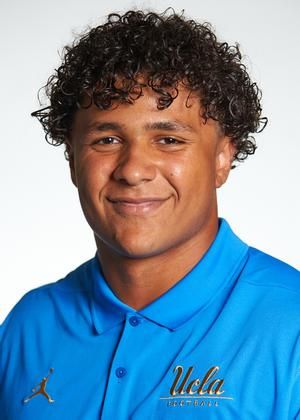 A man with curly hair wearing blue shirt.